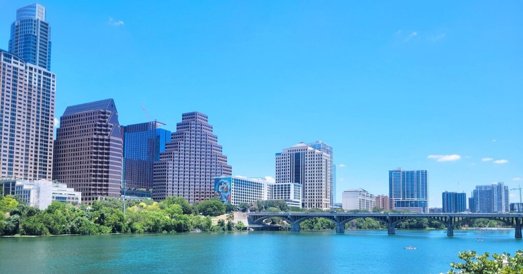 Cheap travel USA: Austin, Texas skyline with buildings, a bridge and a river.