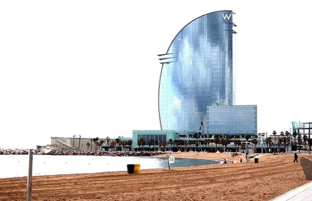 Locals and tourists relaxing on Barceloneta Beach at sunset during a Barcelona vacation